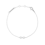 Delicate silver bracelet featuring a slender adjustable chain with a central infinity symbol adorned with white cubic zirconia crystals, crafted from polished stainless steel.