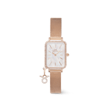 Rose gold women’s watch with a rectangular case, crystal-set bezel, white mother of pearl dial, and a mesh strap featuring an attached sparkling zodiac charm.