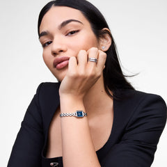Woman wearing the Mirelle Star Earring Silver, featuring a delicate starburst design with sparkling cubic zirconia crystals, styled with a silver bracelet watch and a black top for an elegant, modern look.