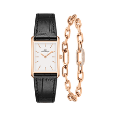Rectangular rose gold watch with a white minimalist dial and black crocodile-embossed leather strap, paired with a rose gold chain bracelet featuring a crystal-encrusted link.