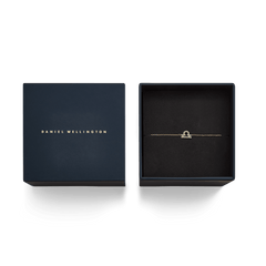Gold crystal zodiac chain bracelet with a delicate Libra pendant displayed in an elegant navy Daniel Wellington gift box.