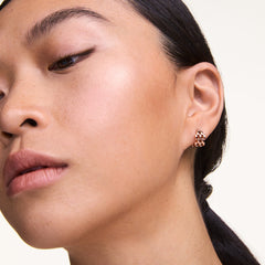 A woman wearing a petite rose gold 5-link earring with a geometric openwork design, styled for a modern and elegant look.