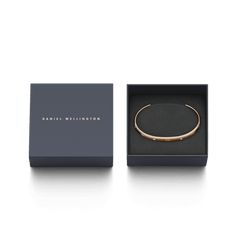 Classic Lumine Bracelet RG in rose gold, featuring a slim open cuff with sparkling crystals, elegantly presented in a navy Daniel Wellington gift box.