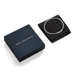 Tide Mesh Bracelet Sterling 2.8 displayed on a black Daniel Wellington pouch beside its elegant branded gift box.