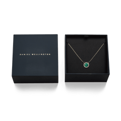 Audrey Necklace Malachite Gold presented in an elegant black Daniel Wellington gift box, featuring a gold chain and a domed green malachite pendant bordered by white cubic zirconia crystals.