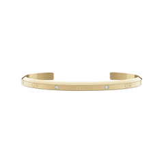 Slim gold cuff bracelet with a polished finish, featuring six sparkling crystals and subtle DW engraving along the band.