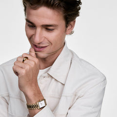 A person wearing the Tide Mesh Necklace Gold 2.8, styled with a cream shirt, gold watch, and gold ring, showcasing the necklace’s fine mesh chain and elegant gold finish for a modern, sophisticated look.