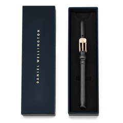 Pressed Sheffield Strap Rose Gold presented in a sleek navy Daniel Wellington gift box, featuring a slim black leather band and a polished rose gold buckle with engraved logo. The packaging highlights its suitability as an elegant gift or stylish watch upgrade.