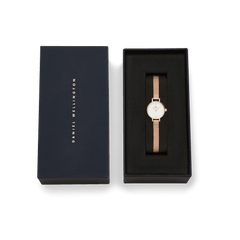 Petite Mini Melrose women's watch with a rose gold mesh strap and minimalist white dial, elegantly presented in a sleek black Daniel Wellington gift box.