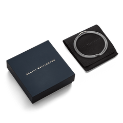 Tide Mesh Necklace Silver 2.8 displayed coiled on a black pouch next to a navy Daniel Wellington gift box, highlighting its refined mesh design and elegant packaging.