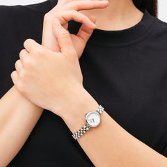 Woman wearing Elan Lumine Silver watch with white dial and crystal markers, styled with a polished silver link strap.