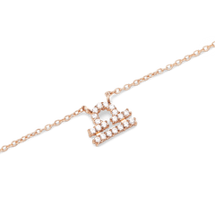 Close-up of a rose gold chain necklace featuring a Libra zodiac pendant adorned with sparkling hand-set crystals.