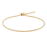 Slim gold snake chain bracelet with an adjustable sliding clasp, crafted from polished stainless steel and finished with a radiant gold tone.