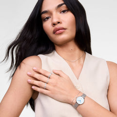 Woman wearing the Mirelle Eternity Ring Silver 1.4 mm on her fingers, styled with a minimalist silver necklace and watch, showcasing the ring’s slender band and sparkling cubic zirconia crystals for an elegant, contemporary look.