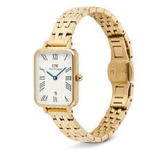 Daniel Wellington Quadro Roman Numerals Date 5-link Gold watch featuring a rectangular gold case, white dial with Roman numerals, blue hands, date window at 6 o’clock, and a polished 5-link gold stainless steel strap with butterfly clasp.