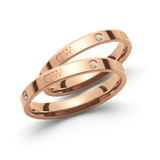 Pair of polished rose gold rings featuring sparkling stones and the Daniel Wellington engraving, showcasing a refined band design with a sophisticated, modern classic finish.