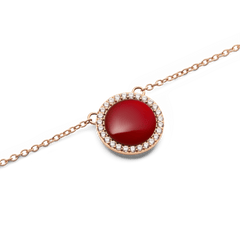 Close-up of Audrey Necklace pendant featuring a domed red agate stone with a halo of white cubic zirconia in rose gold.