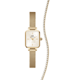 Rectangular gold mesh Daniel Wellington Quadro Mini watch with a champagne dial, paired with a gold tennis necklace featuring a row of sparkling crystals.