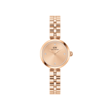 Rose gold Daniel Wellington women’s watch featuring a minimalist round dial with four crystal hour markers and a polished three-link bracelet.