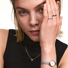 Model wearing the Crystal Zodiac Chain Necklace Silver with an Aquarius pendant, styled with a sleeveless black top and silver accessories.