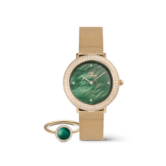 Gold Daniel Wellington watch with a mesh strap, emerald green dial, and crystal-set bezel, paired with a matching gold ring featuring a green stone and delicate crystal accents.