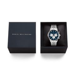 Daniel Wellington Iconic Chronograph Arch 5-Link Arctic Panda Silver watch with a blue dial and silver sub-dials, presented in a sleek branded gift box.