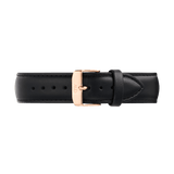 Black leather watch strap with a tapered design, detailed stitching, and a rose gold PVD-plated stainless steel pin buckle engraved with the Daniel Wellington logo. The strap features a smooth, supple finish and a quick-release connector for easy attachment.