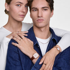 The Marlon & Jolie Chain Rose Gold Set shown worn by a couple, featuring the Marlon watch with a rose gold case, textured white dial and brown leather strap, alongside the Jolie Chain watch with a petite square face and polished rose gold chain bracelet.