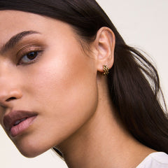 Gold 5-link earring with a geometric, interlocking design worn on the ear, showcasing its polished finish and modern style.