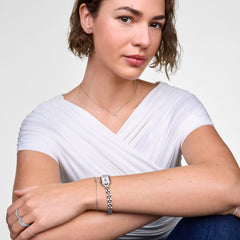 Woman wearing the Mirelle Heart Bracelet Silver on her wrist, styled alongside a silver watch and matching jewellery, highlighting the bracelet’s delicate open heart charm and minimalist design.
