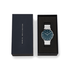 Classic Piano Link Arctic Silver watch with a brushed arctic blue dial and silver piano link strap, presented in an elegant black Daniel Wellington gift box.
