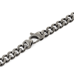 Detail of the Ellipse Cuban Chain Necklace in graphite, highlighting the polished flat Cuban links and the secure matching lobster clasp engraved with the Daniel Wellington logo.
