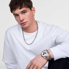 Man wearing the Ellipse Cuban Chain Necklace Silver, styled with a white crew neck top and paired with a matching silver bracelet and watch for a modern, polished look.