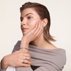 A woman wearing the 3-Link Ring Silver on her finger, styled with matching silver jewellery including a bracelet and earrings, showcasing the ring’s bold geometric links and polished finish.