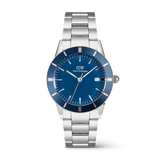 Men’s silver stainless steel watch with a deep blue enamel dial, anodised aluminium bezel, and three-link bracelet, featuring minimalist hour markers and a date display at 3 o’clock.