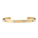 Polished gold cuff bracelet with a minimalist open design, featuring eight evenly spaced cubic zirconia crystals set along the band for a refined and elegant look.