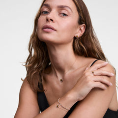 Woman wearing Audrey Earrings in Tiger Eye Gold, styled with matching gold necklace, bracelet, and ring.