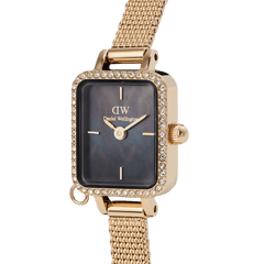 Close-up of the Quadro Mini Crystal Zodiac Evergold watch, highlighting its gold rectangular case with a crystal-set bezel, black mother of pearl dial, and gold mesh strap.