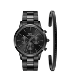 Sleek black chronograph watch with a stainless steel link strap, paired with a matching slim black cuff bracelet featuring subtle Daniel Wellington branding, both showcasing a modern and sophisticated design.