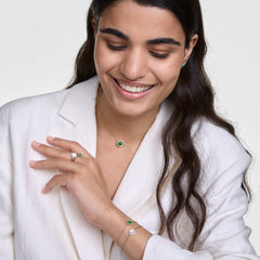 Woman wearing Audrey Ring Mother of Pearl Gold with matching gold jewellery, styled with a white blazer for an elegant look.