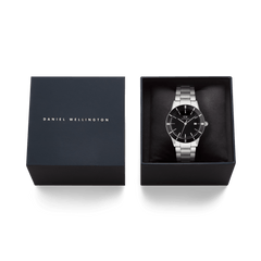 Daniel Wellington Iconic Paradigma Link Black Enamel watch presented in an elegant branded gift box, featuring a black dial, silver stainless steel bracelet, and bold index bezel.