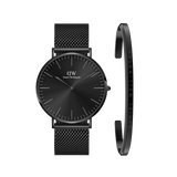 Sleek black Daniel Wellington mesh watch with a minimalist onyx dial, paired with a matching slim black steel bracelet engraved with the brand name, both featuring a modern and timeless design.