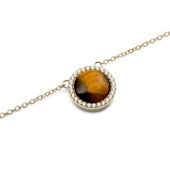 Close-up of Audrey Necklace Tiger Eye Gold featuring a domed Tiger Eye stone framed by sparkling cubic zirconia on a gold chain.