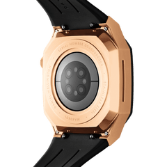 Close-up of the Switch Rose Gold Apple Watch case showing the brushed rose gold stainless steel back, engraved detailing, and black synthetic rubber strap.