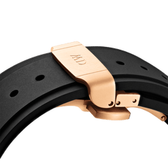 Close-up of the Switch Rose Gold Apple Watch case’s black synthetic rubber strap with a brushed rose gold deployment clasp engraved with initials.