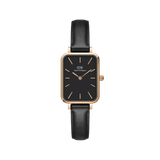 Rectangular women’s watch with a black dial, rose gold case and markers, and a slim black leather strap.