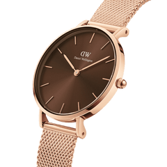 Petite Amber women’s watch in rose gold with a sunray amber brown dial and a fine mesh strap, shown in a close-up angled view.