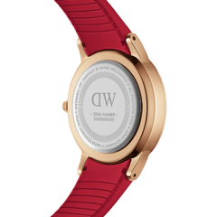 Rear view of the Daniel Wellington Iconic Motion Ruby watch showing the engraved stainless steel case back, rose gold finish, and textured ruby red rubber strap.