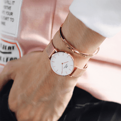 Rose gold Daniel Wellington Classic Bracelet styled with matching mesh strap watch on wrist, paired with a casual outfit.