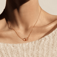 Woman wearing Elan Unity Necklace in rose gold with interlocking circles, delicate chain, minimalist jewellery styling.